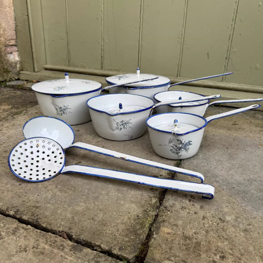 White enameled saucepans and skimmer with blue details