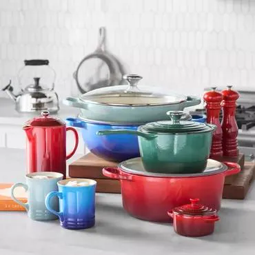 Enameled cast iron cookware and mugs in vibrant colors